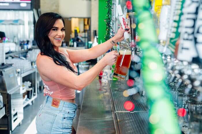 Bartender pouring a draft beer at Backyard Dallas.
