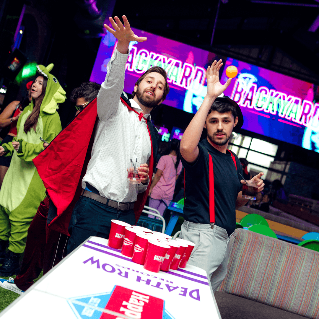Two men playing Halloween beer pong
